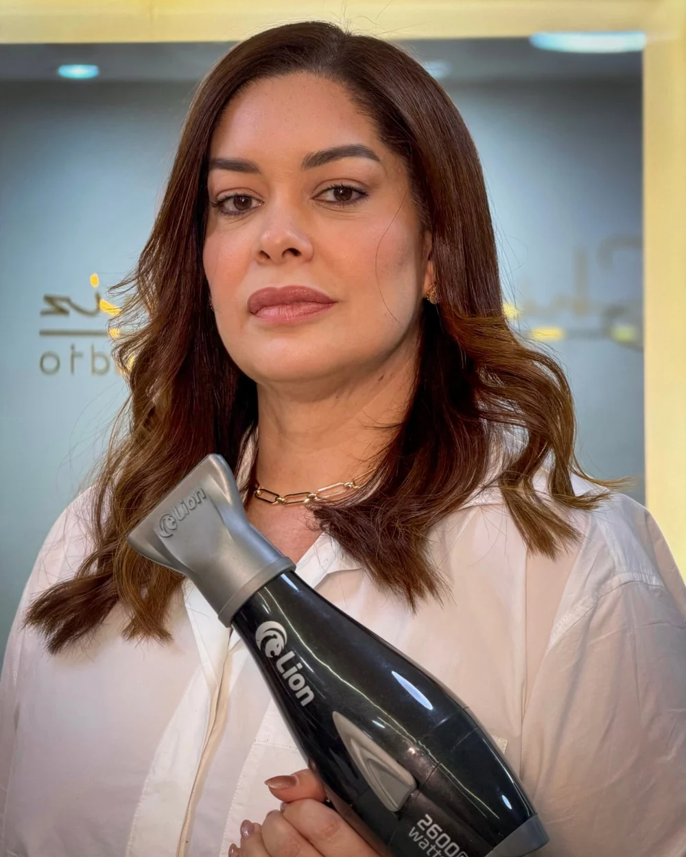 Shirley Diniz segurando um secador de cabelo